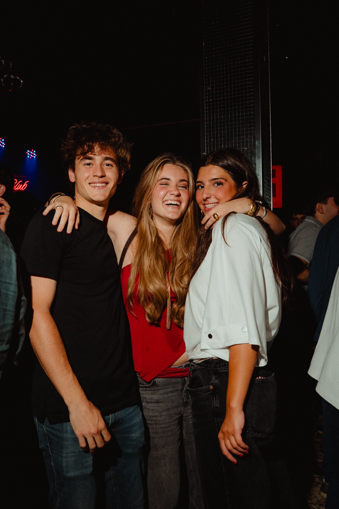 Amigos sonriendo en una noche en Quartier Barcelona